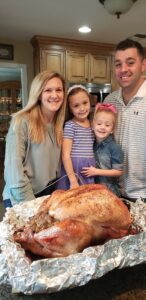 Family at Spring Valley Turkey Farm with cooked Thanksgiving turkey in Old Bridge NJ