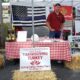 Spring Valley Turkey Farm booth at a local New Jersey event featuring farm-fresh Thanksgiving turkey signage, hay bales, patriotic flags, and display table.