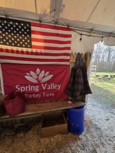 Spring Valley Turkey Farm veteran-owned New Jersey farm display with American flag and farm sign inside rustic barn setting