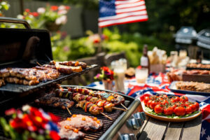 Memorial Day backyard cookout with grilled food, pasta salad, watermelon, lemonade, and American flag decorations.